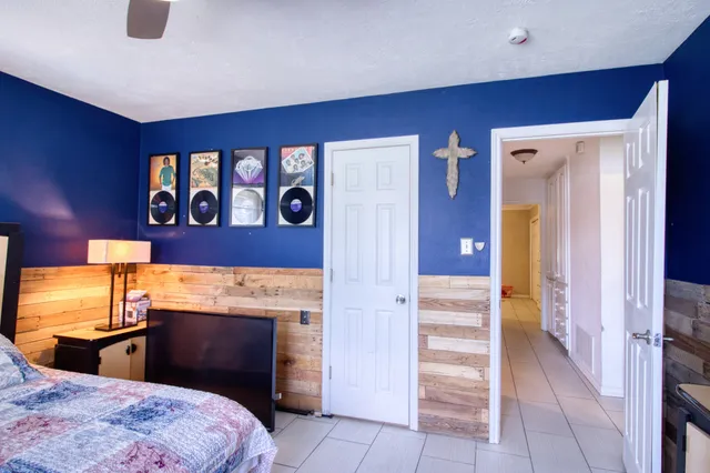 a bedroom with a bed and a lamp on dresser