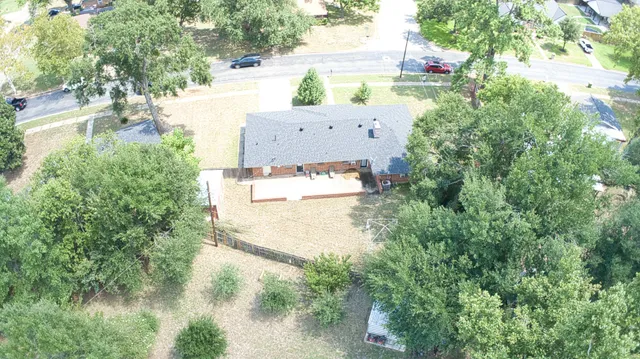 an aerial view of residential houses with outdoor space and trees