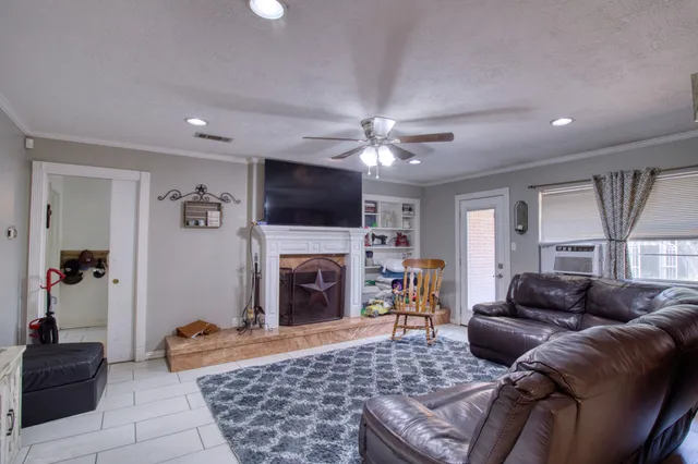 a living room with furniture a flat screen tv and a fireplace