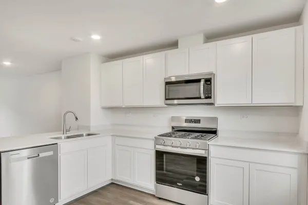 a kitchen with white cabinets stainless steel appliances and sink