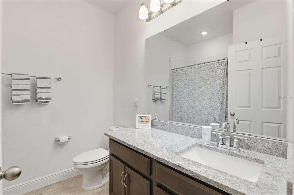 2420 Firstlight Way Winter Park, FL 32792 - Photo 25 of 48 a bathroom with a granite countertop sink a toilet and a mirror
