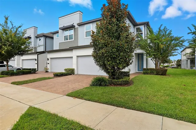 a front view of a house with a yard and trees