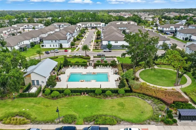 an aerial view of residential houses with outdoor space and parking