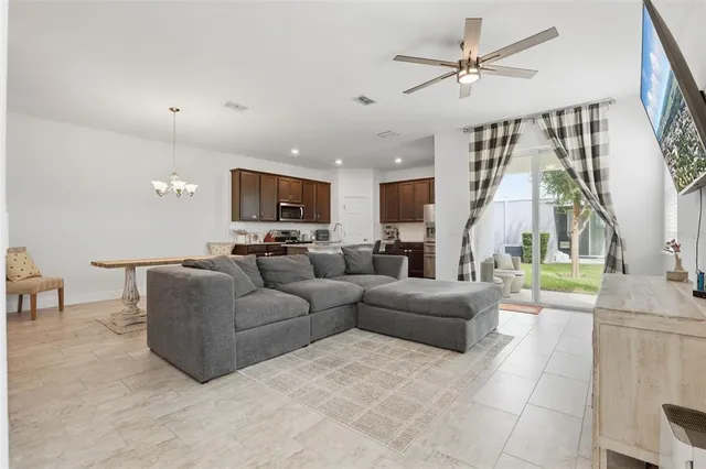 a living room with furniture a ceiling fan and a rug