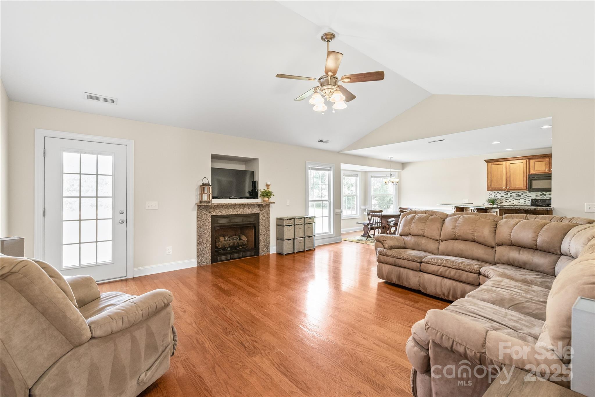 8717 Swift Road Oakboro, NC 28129 - Photo 3 of 23 a living room with furniture a fireplace and a flat screen tv