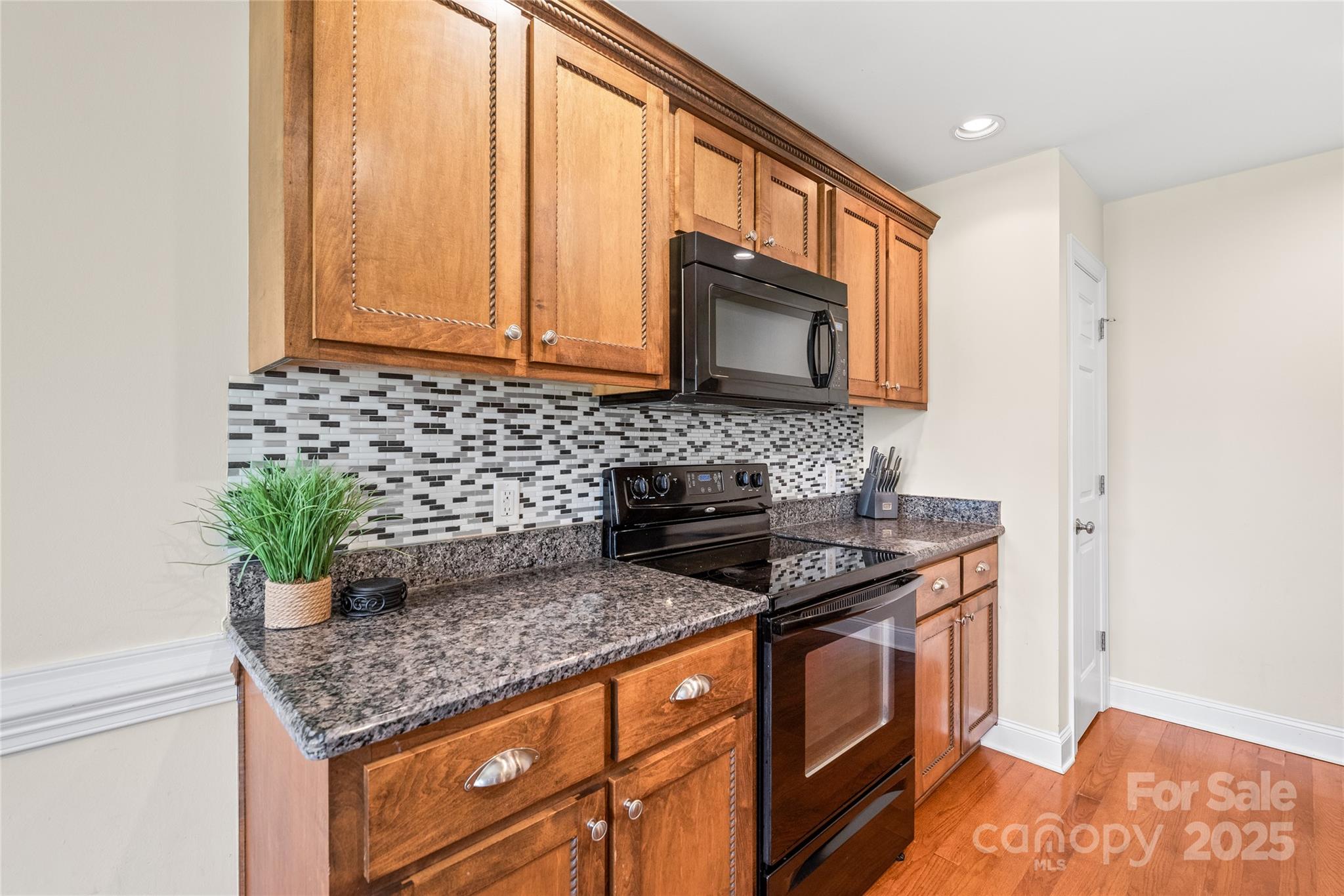 8717 Swift Road Oakboro, NC 28129 - Photo 6 of 23 a kitchen with stainless steel appliances granite countertop a sink stove and microwave