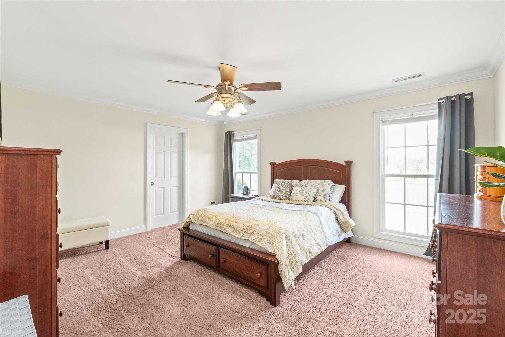 8717 Swift Road Oakboro, NC 28129 - Photo 9 of 23 a bedroom with a large bed and a chandelier