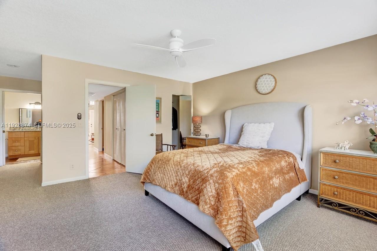 5170 Nesting Way, Unit B Delray Beach, FL 33484 - Photo 11 of 16 a bedroom with a bed and closet with mirror