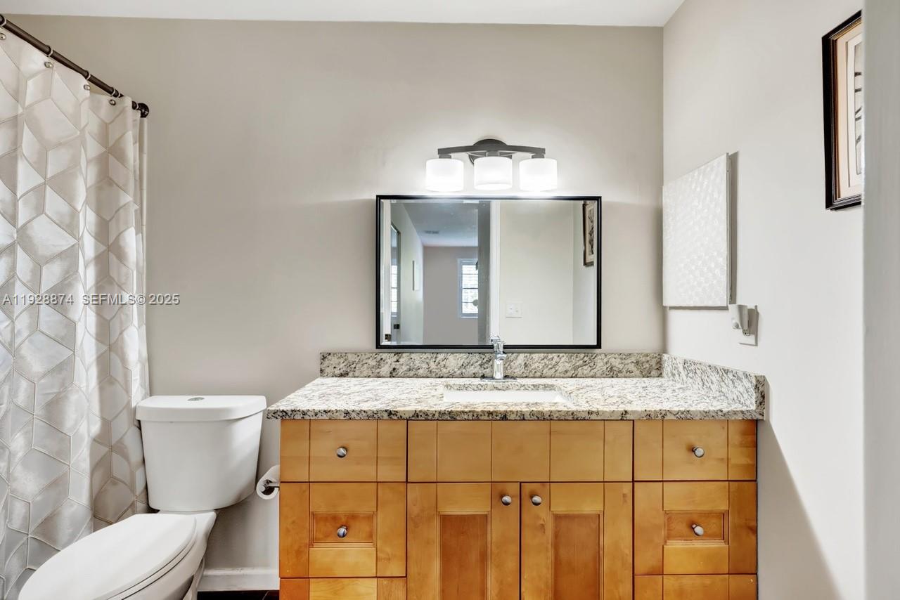 5170 Nesting Way, Unit B Delray Beach, FL 33484 - Photo 13 of 16 a bathroom with a granite countertop toilet sink and mirror