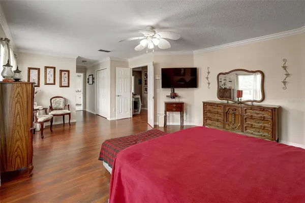 a spacious bedroom with a bed and a flat screen tv
