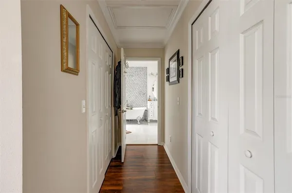 a view of a hallway with wooden floor and closet