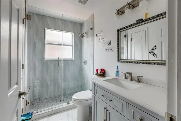 a bathroom with a sink a toilet and shower