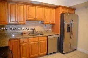a kitchen with stainless steel appliances granite countertop a refrigerator and a sink