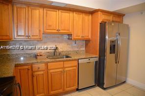 a kitchen with stainless steel appliances granite countertop a refrigerator and a sink