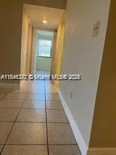 a view of a livingroom with a flesh screen tv and window