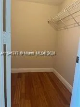 a view of water heater room with wooden floor