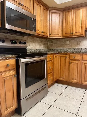 a kitchen with granite countertop cabinets stainless steel appliances and a sink