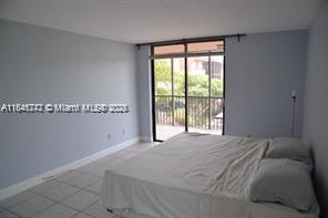 20850 San Simeon Way, Unit 3095 Miami, FL 33179 - Photo 9 of 20 a bed sitting in a bedroom next to a window