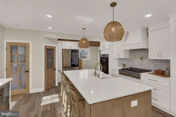 a kitchen with stainless steel appliances granite countertop a sink a microwave oven and a refrigerator with wooden floor