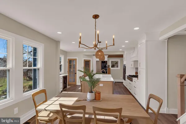 a view of a dining room with furniture a kitchen and chandelier
