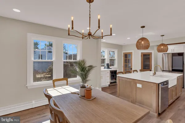 a view of a dining room with furniture a chandelier and wooden floor