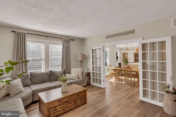 a living room with furniture a dining table and a large window