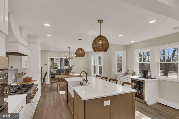 a room with stainless steel appliances kitchen island a table and chairs in it