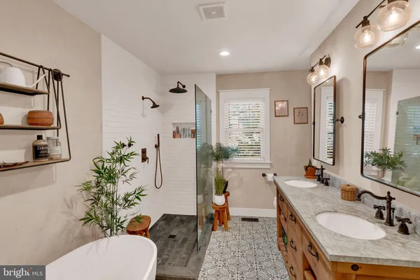 a spacious bathroom with a granite countertop sink a toilet a mirror and shower