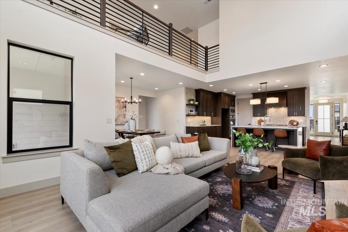 7624 West Old School Street, Unit FREMONT Meridian, ID 83646 - Photo 12 of 35 Living room featuring a high ceiling, wood finished floors, and suspended lighting