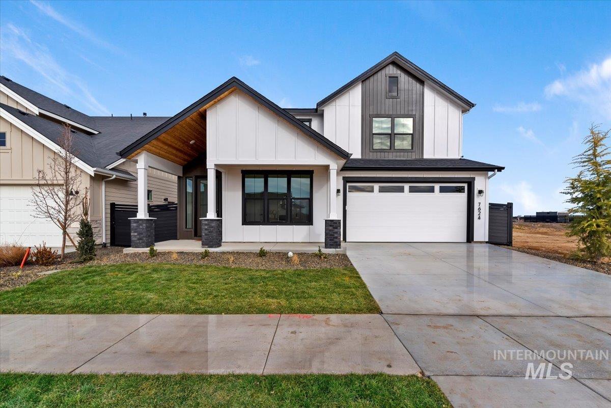 7624 West Old School Street, Unit FREMONT Meridian, ID 83646 - Photo 2 of 35 Modern farmhouse with board and batten siding, an attached garage, concrete driveway, covered porch, and a front yard