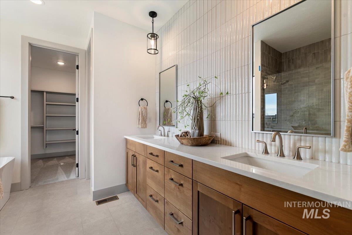 7624 West Old School Street, Unit FREMONT Meridian, ID 83646 - Photo 24 of 35 Bathroom featuring a stall shower, a spacious closet, double vanity, a freestanding tub, and light tile patterned floors