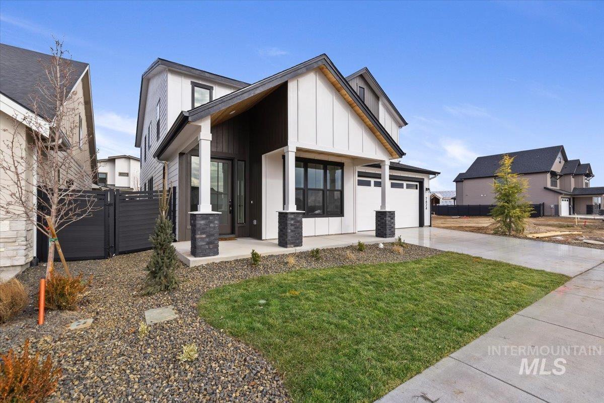 7624 West Old School Street, Unit FREMONT Meridian, ID 83646 - Photo 3 of 35 View of front of house with board and batten siding, concrete driveway, a gate, covered porch, and a garage