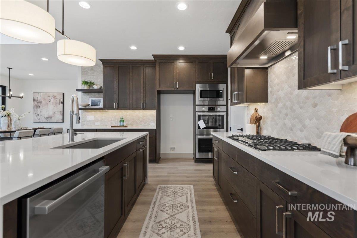 7624 West Old School Street, Unit FREMONT Meridian, ID 83646 - Photo 8 of 35 Kitchen featuring dark wood finish cabinetry, stainless steel appliances, light stone counters, light wood finished floors, and open shelves