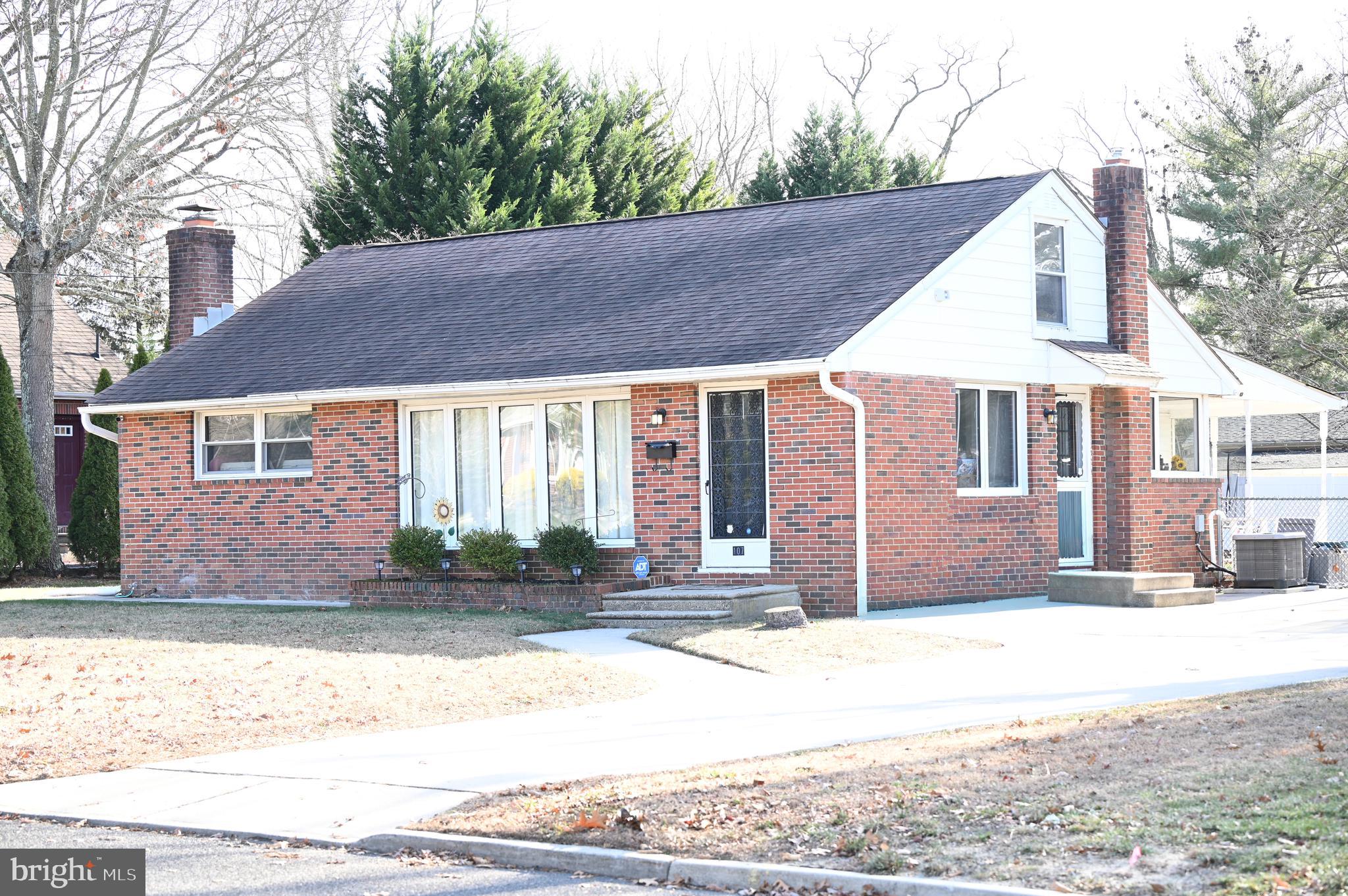 a view of a house with a yard and large tree