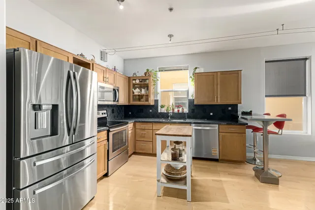 a kitchen with stainless steel appliances granite countertop a refrigerator sink and stove