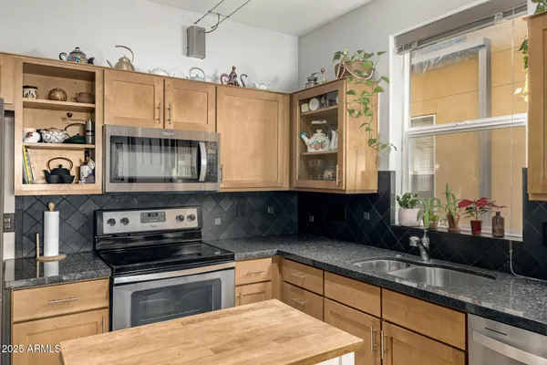 a kitchen with stainless steel appliances a sink stove and cabinets