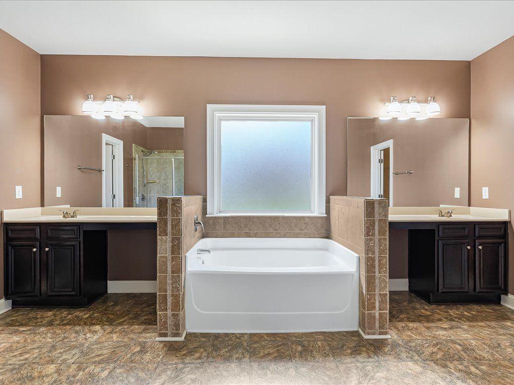 80 Lanier Ridge Acworth, GA 30101 - Photo 36 of 59 a bathroom with a tub a double vanity sink and a mirror