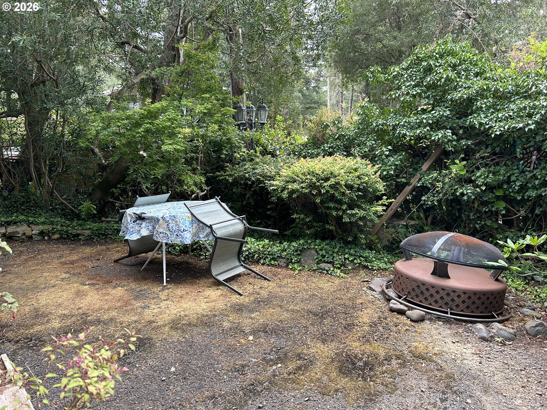 112 Sailor Lane Florence, OR 97439 - Photo 7 of 44 a couple of chairs sitting in a backyard with large trees