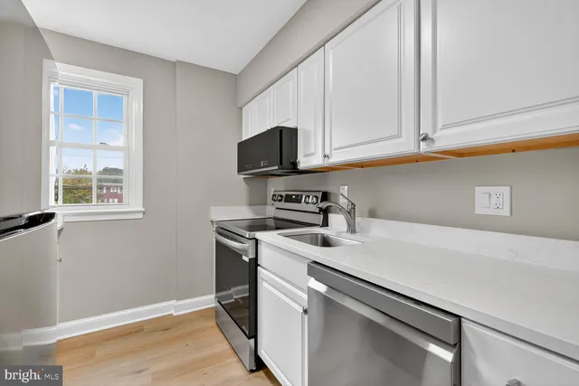 a kitchen with stainless steel appliances white cabinets and a microwave oven