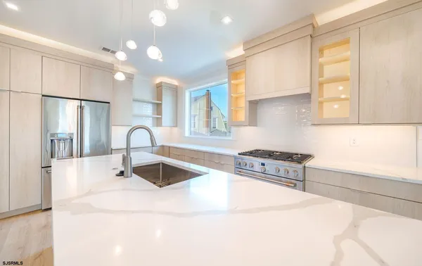 a kitchen with granite countertop a sink a stove and refrigerator