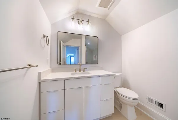 a bathroom with a toilet a sink and mirror