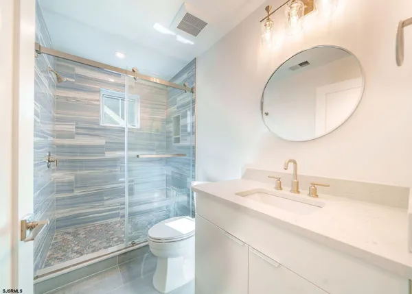 a bathroom with a sink a toilet and shower