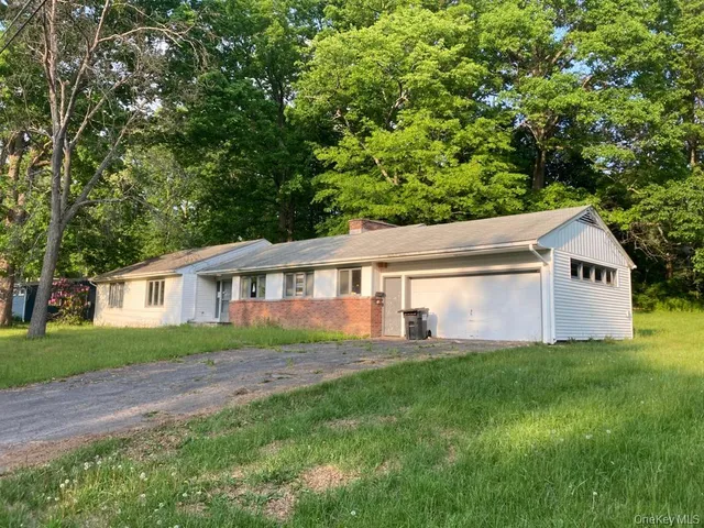 a front view of a house with a yard and trees