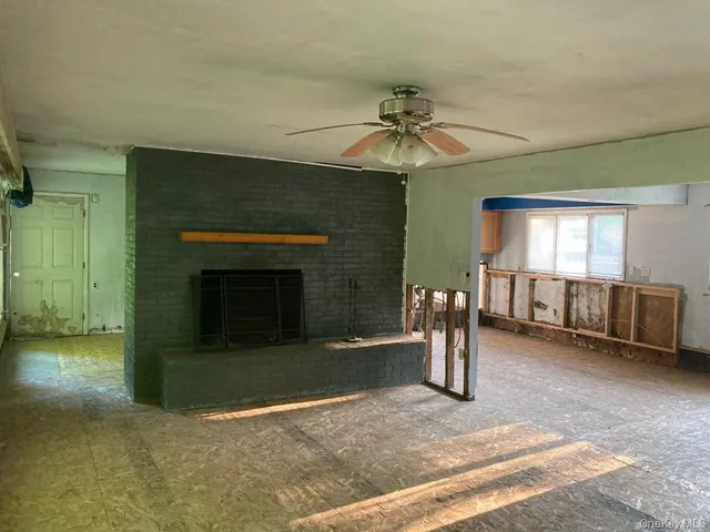 an empty room with windows and fireplace