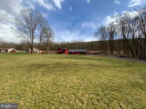a view of a field with an trees in front of it