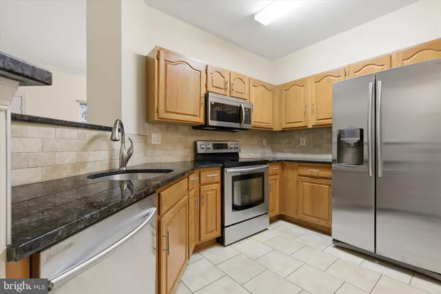 a kitchen with granite countertop a sink stove and refrigerator