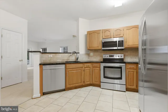 a kitchen with stainless steel appliances granite countertop a stove microwave and refrigerator