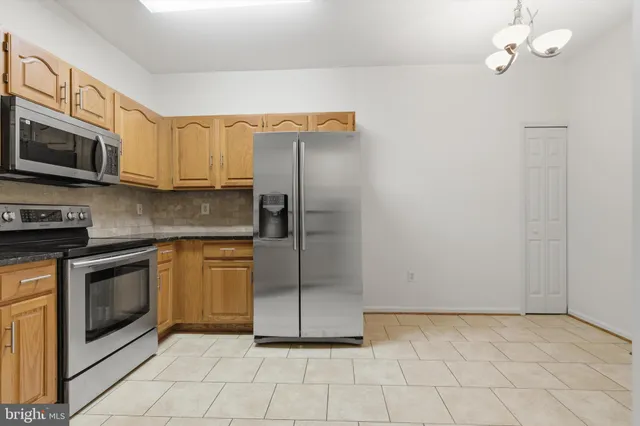 a kitchen with stainless steel appliances granite countertop a stove a microwave and a refrigerator