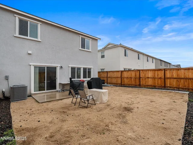 a backyard of a house with table and chairs