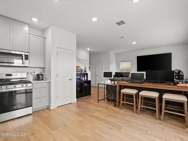 a large white kitchen with stainless steel appliances granite countertop a stove and a refrigerator